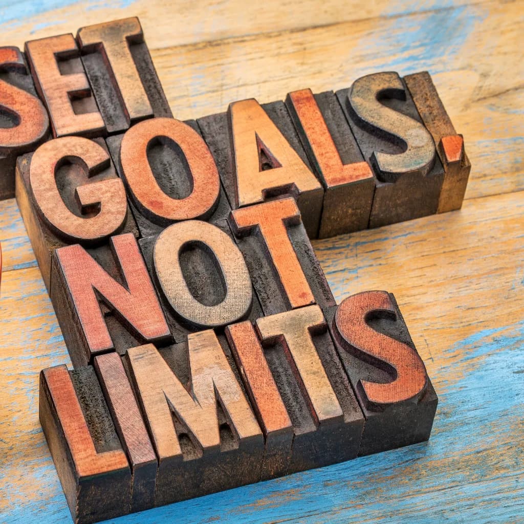 Holzlettern bilden den Satz „Set goals, not limits!“