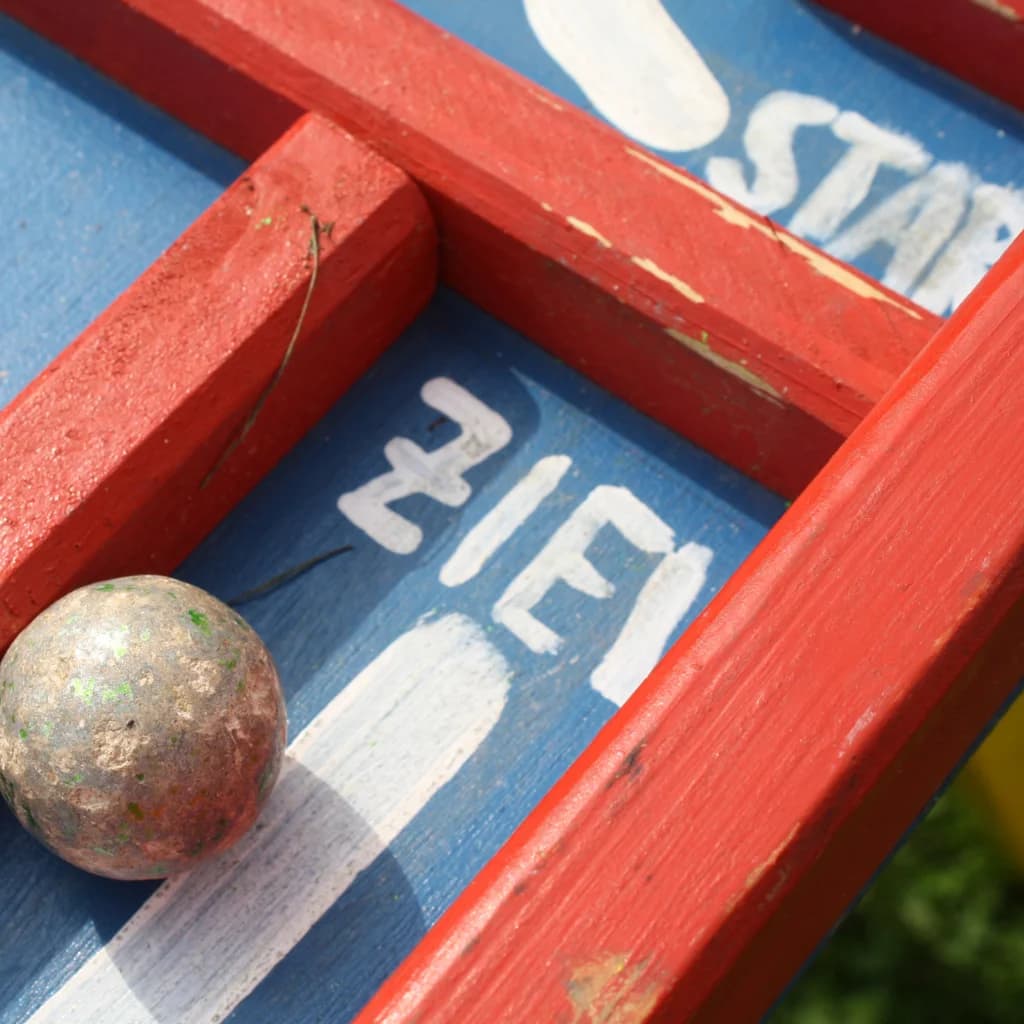 Rote Holzleiter auf einem blauen Spielbrett mit den Worten „Start“ und „Ziel“