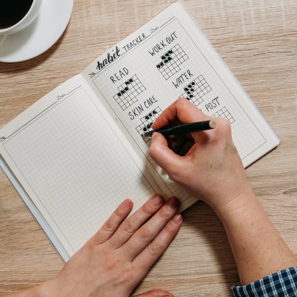 Habit-Tracker in einem Notizbuch, Hand hakt Gewohnheiten ab