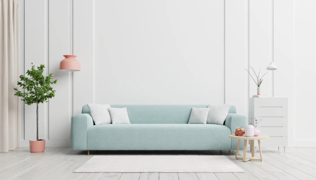 Aufgeräumtes helles Wohnzimmer mit mintgrünem Sofa und Pflanze