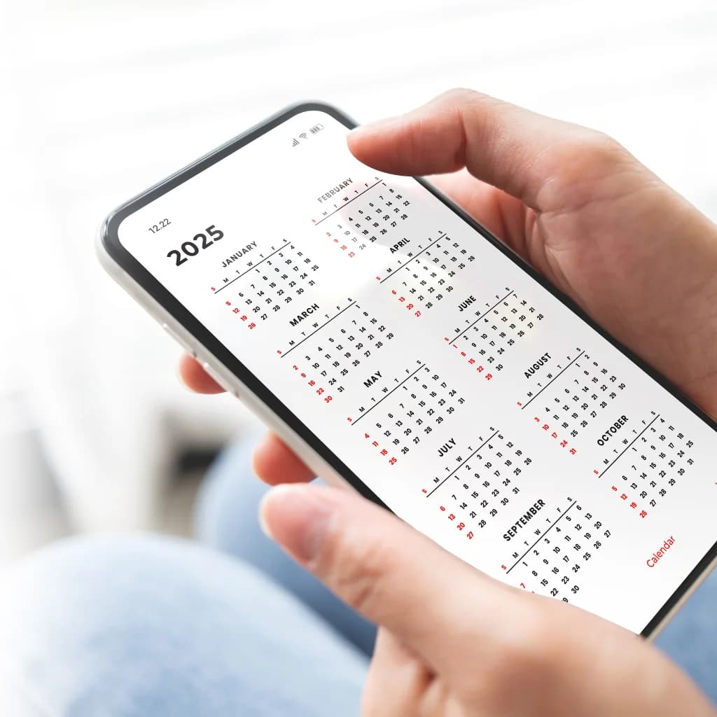 Hände halten ein Smartphone mit einer Jahresübersicht 2025